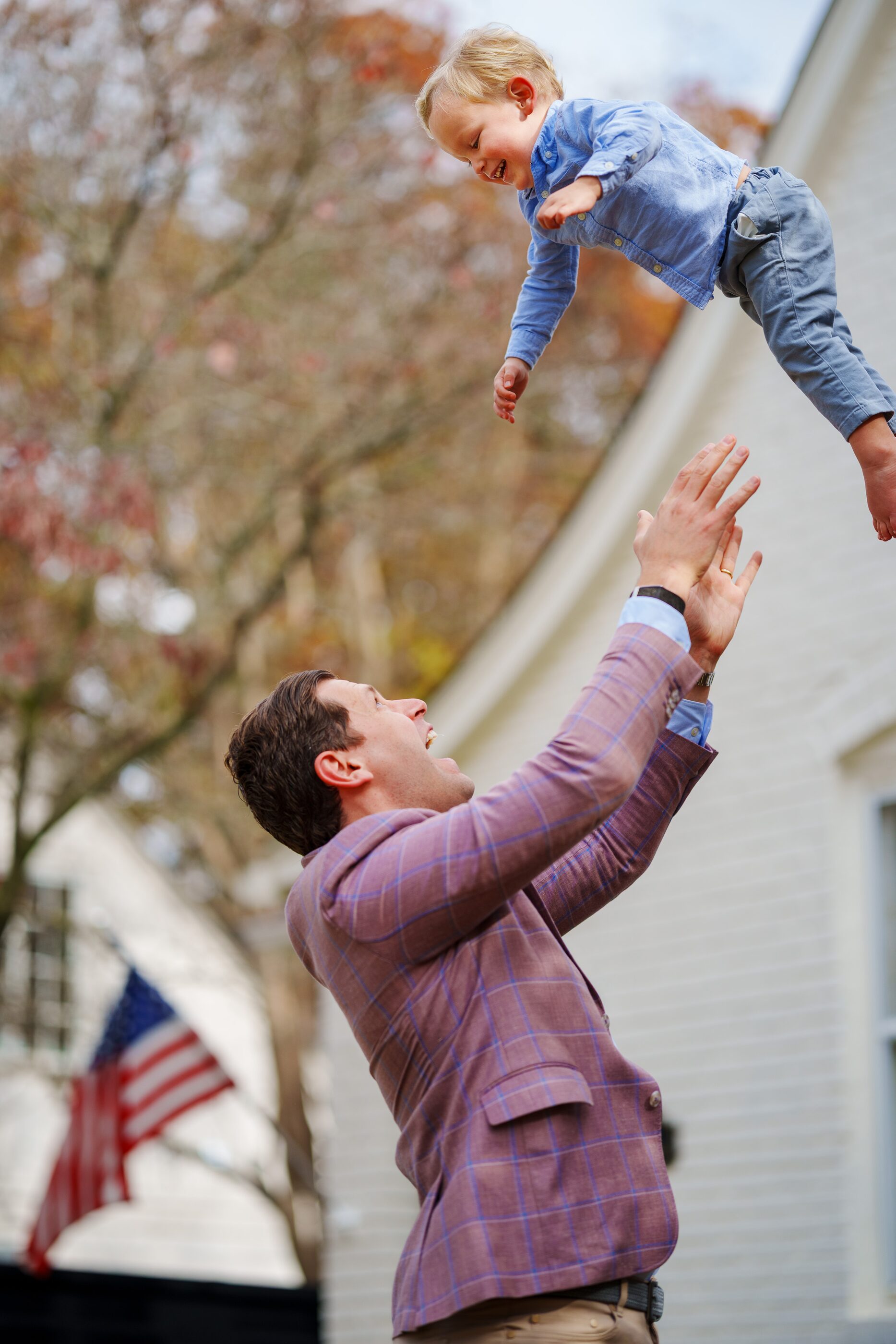 A parent lifting a laughing child into the air